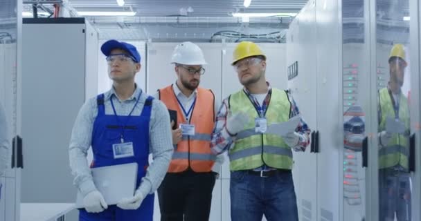 Trabajadores eléctricos caminando en la sala de control — Vídeo de stock