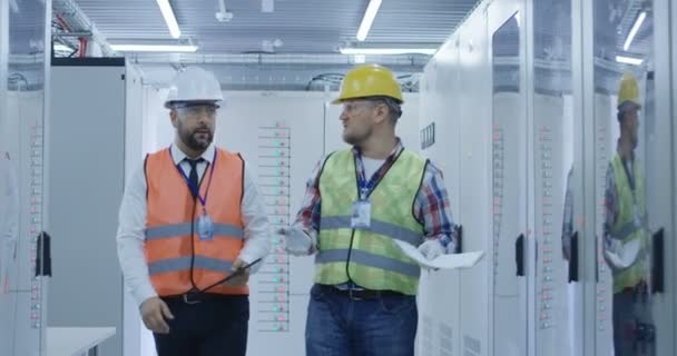 Ingenieros que trabajan con equipos eléctricos en la estación — Vídeo de stock