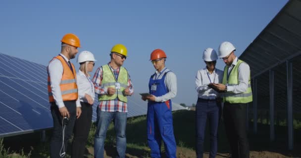 Trabalhadores elétricos que inspecionam uma fazenda solar — Vídeo de Stock