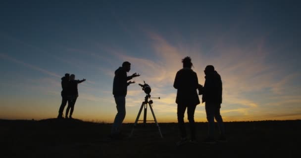 Amigos mirando juntos usando un telescopio profesional — Vídeo de stock