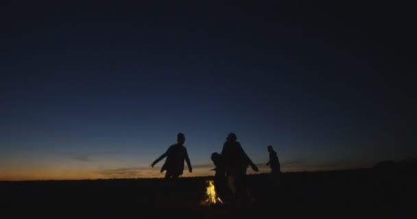 Silhouetten von Menschen, die Spaß am Lagerfeuer haben — Stockvideo