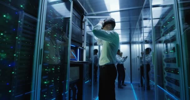 Técnico trabaja en un centro de datos con auriculares VR — Vídeo de stock