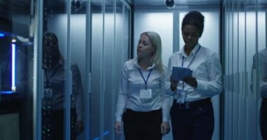 İki kadın bir veri merkezinde sunucu rafları satırlarının ile çalışıyoruz