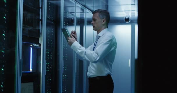 Technicus werkt op een tablet in een datacenter — Stockvideo