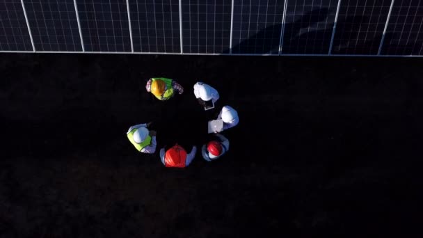 Drone view of engineers on field with solar panels — Stock Video