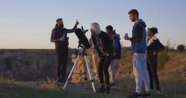 Amigos mirando juntos usando un telescopio profesional — Vídeos de Stock