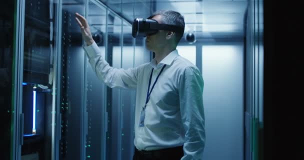 Technician works in a data center wearing a VR headset — Stock Video