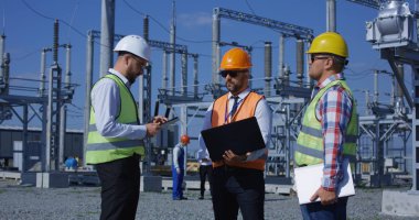 Becerikli alet ile güneş santrali üzerinde çeşitli işçilerin Grup