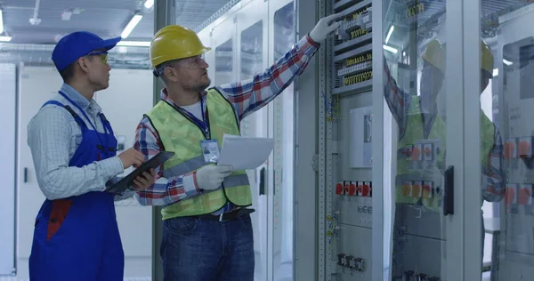 Dos trabajadores eléctricos inspeccionando equipos — Foto de Stock