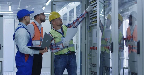 Trabajadores eléctricos que trabajan en la sala de control — Foto de Stock