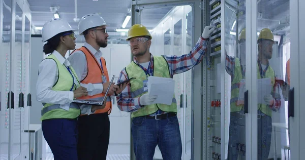 Diversos ingenieros con papeles que trabajan en el centro de control entre bastidores — Foto de Stock