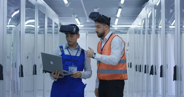 Trabajadores eléctricos en chalecos reflectantes con auriculares VR — Foto de Stock