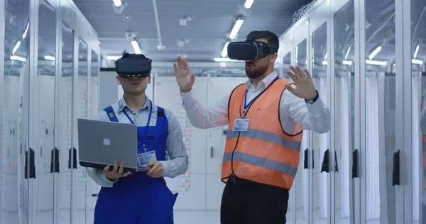 Trabajadores eléctricos en chalecos reflectantes con auriculares VR — Foto de Stock