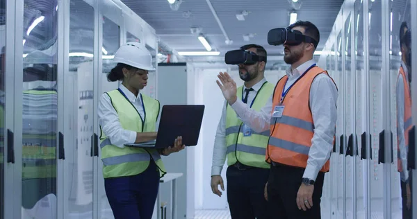 Trabajadores eléctricos en chalecos reflectantes utilizando VR — Foto de Stock