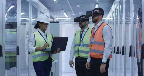 Trabajadores eléctricos en chalecos reflectantes utilizando VR — Foto de Stock