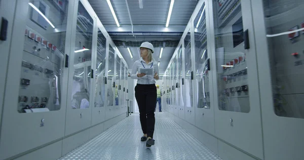 Female electrical worker walking down the hall — Stock Photo, Image