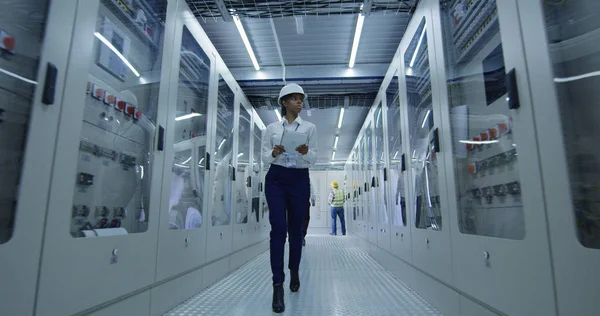 Female electrical worker walking down the hall