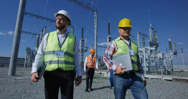 Trabajadores eléctricos caminando afuera — Foto de Stock