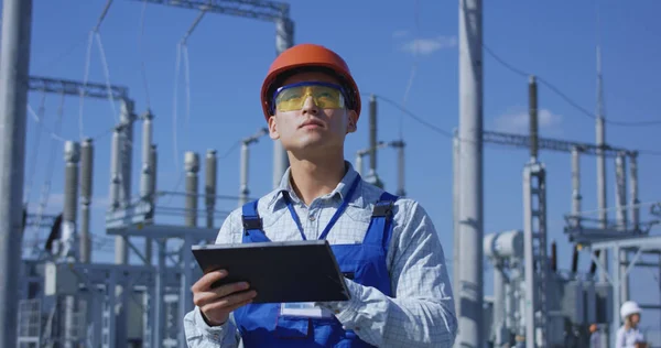 Trabajador eléctrico en una tableta exterior — Foto de Stock
