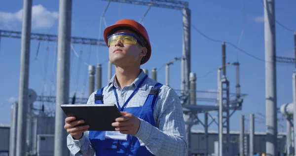 Electrical worker on a tablet outside