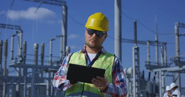 Trabajador eléctrico en una tableta exterior — Foto de Stock