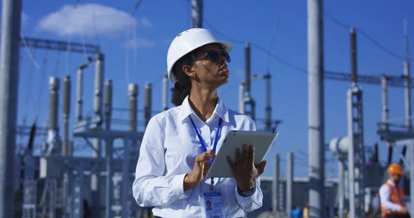 Svart kvinna med tablett arbetar på solenergi anläggning — Stockfoto