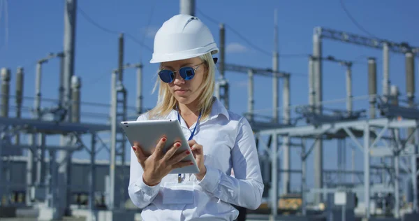 Trabajadora eléctrica sonriente en una tableta — Foto de Stock