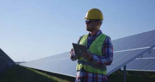 Dla dorosłych inżynier przy użyciu tabletu pracę wśród paneli słonecznych — Zdjęcie stockowe