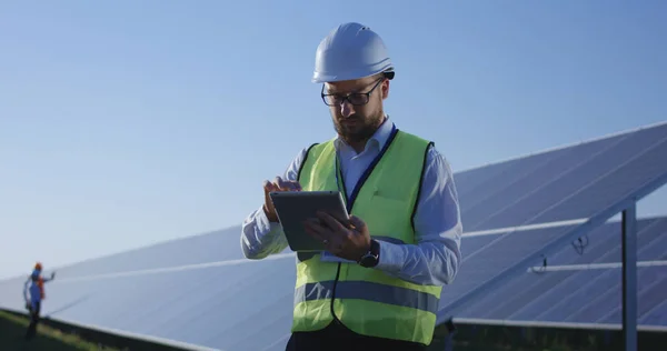 Elektrische arbeider te typen op zijn tablet buiten — Stockfoto