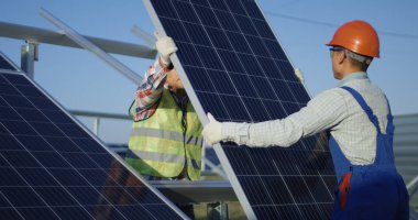 Two workers install a solar panel clipart