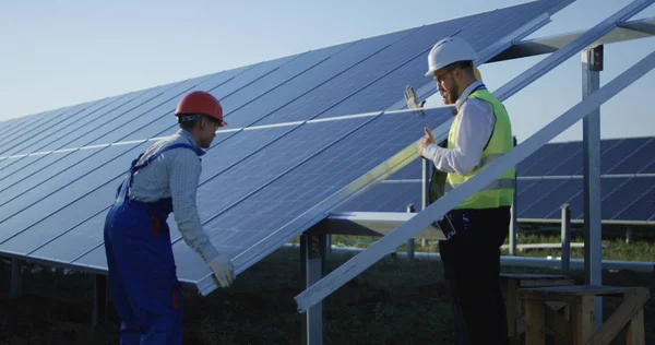 Tres trabajadores instalan un panel solar —  Fotos de Stock