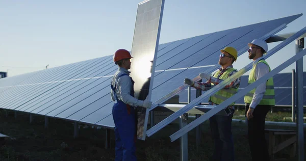 Tres trabajadores instalan un panel solar —  Fotos de Stock