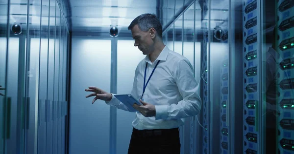 Técnico trabaja en una tableta en un centro de datos — Foto de Stock