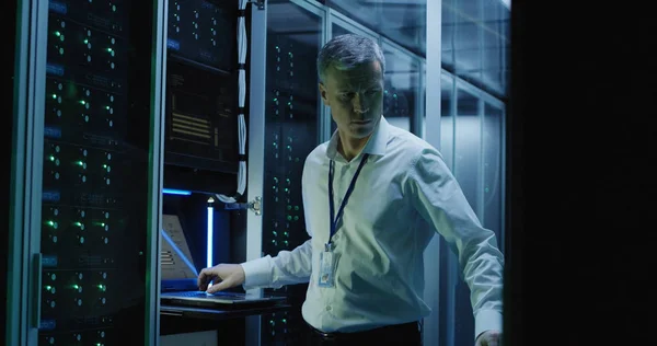 Técnicos trabajan en un ordenador portátil en un centro de datos — Foto de Stock