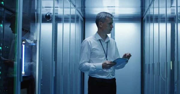 Technician works on a tablet in a data center — Stock Photo, Image