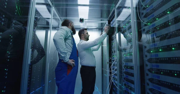 Два чоловіки, які виконують технічне обслуговування в центрі обробки даних — стокове фото