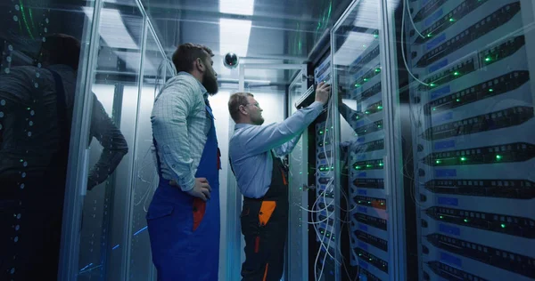 Dos hombres realizando mantenimiento en un centro de datos — Foto de Stock