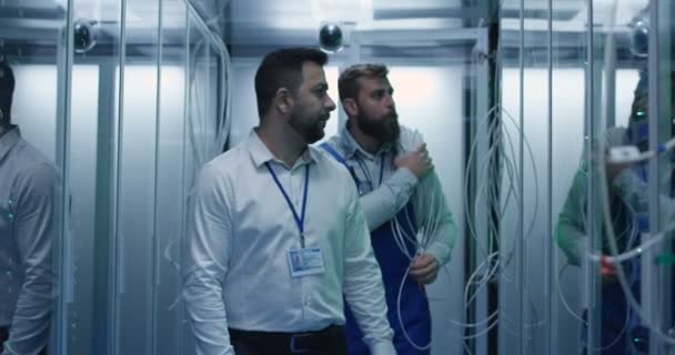 Manager och tekniker som arbetar i ett datacenter — Stockvideo