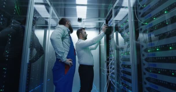 Dos hombres realizando mantenimiento en un centro de datos — Vídeo de stock