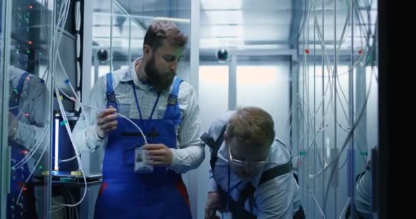 Zwei männliche Techniker arbeiten in einem Rechenzentrum — Stockvideo