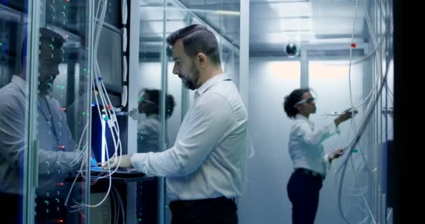 Los ingenieros trabajan con cables en la sala de servidores — Vídeo de stock