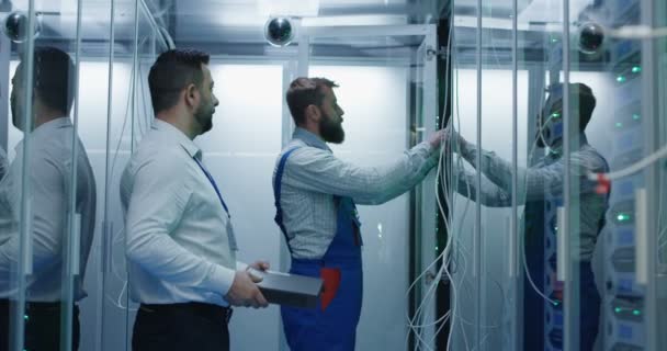 Twee mannen het uitvoeren van onderhoud in een datacenter — Stockvideo