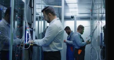 Üç kişi bir veri merkezi kablosu ile çalışma