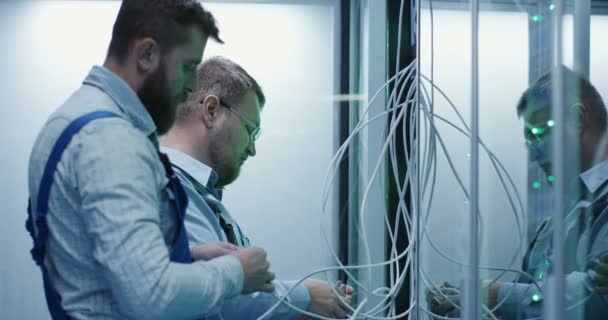 Twee mannelijke technici die werken in een datacenter — Stockvideo