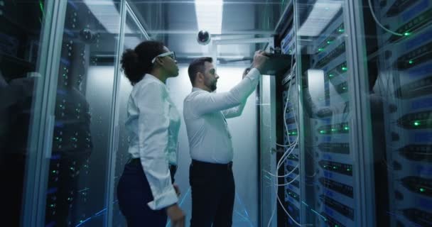 Dos empleados realizando mantenimiento en un centro de datos — Vídeo de stock