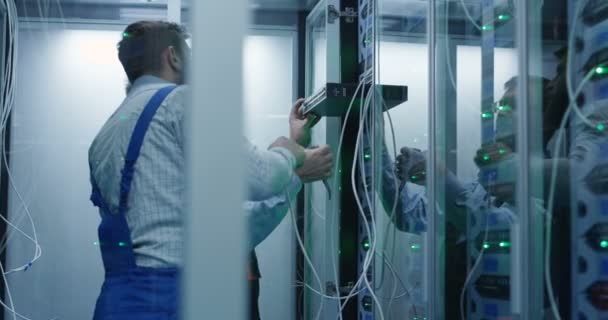 Två manliga tekniker som arbetar i ett datacenter — Stockvideo