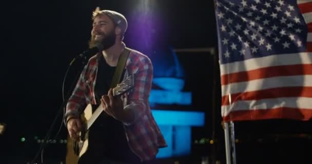 Cantor masculino em camisa xadrez cantando e tocando guitarra — Vídeo de Stock