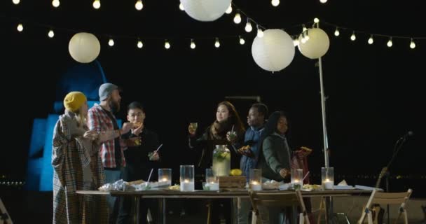 Amigos hablando y comiendo pizza en una fiesta en la azotea — Vídeos de Stock