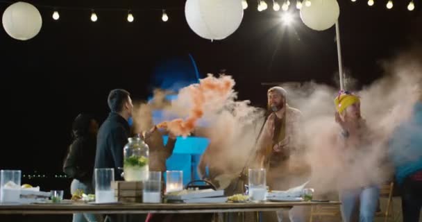 Gente bailando con humo de colores en una azotea — Vídeo de stock