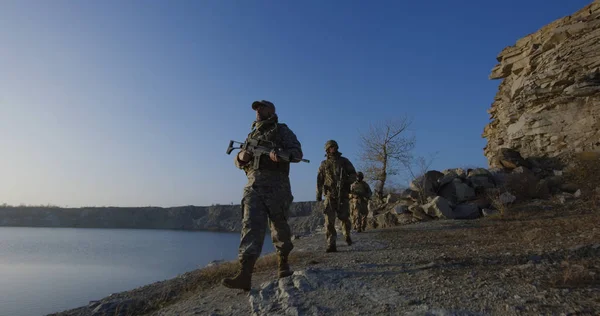 Gewapende soldaten wandelen door een meer — Stockfoto